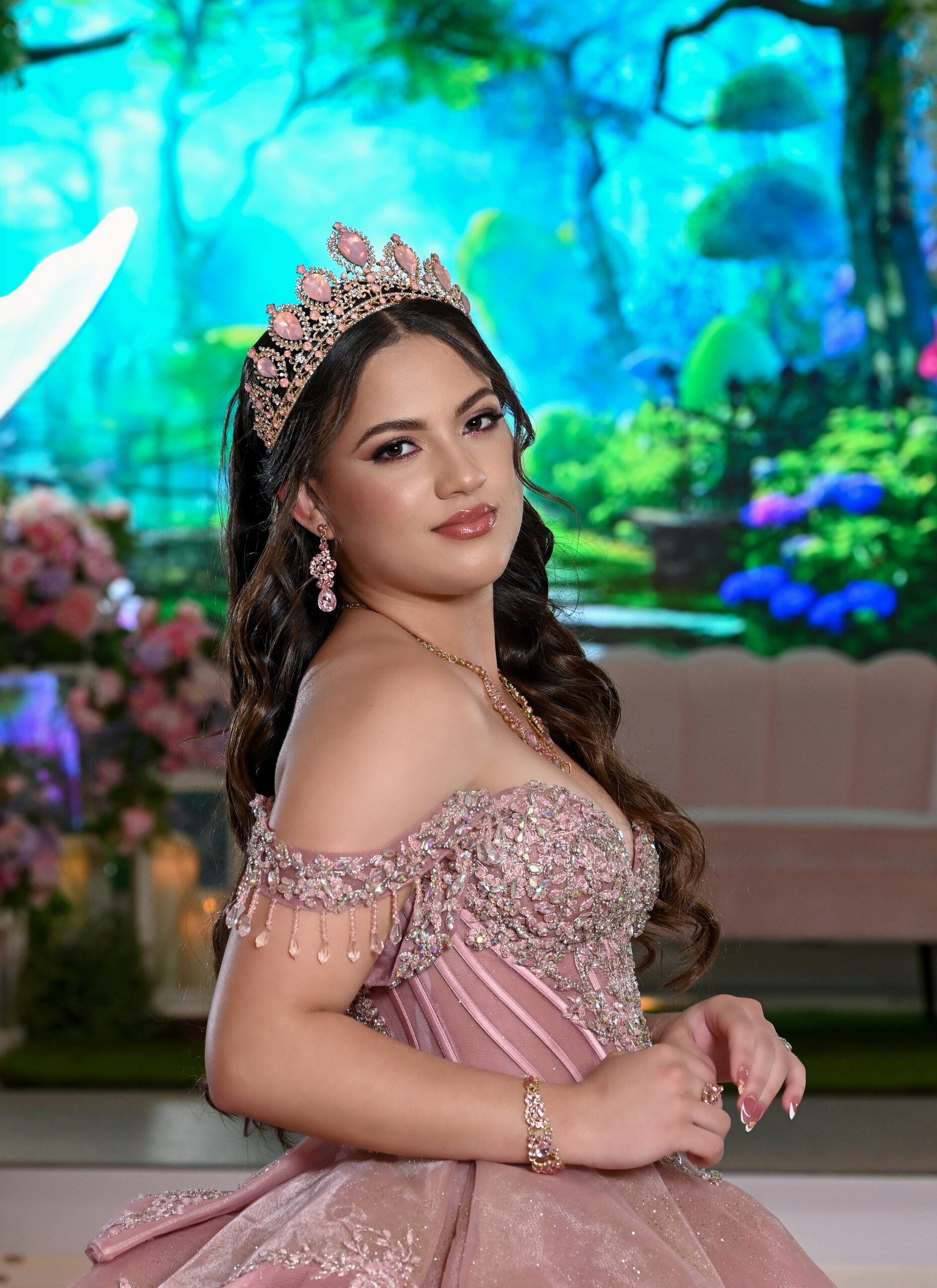 A quinceañera in front of the hall's LED backdrop