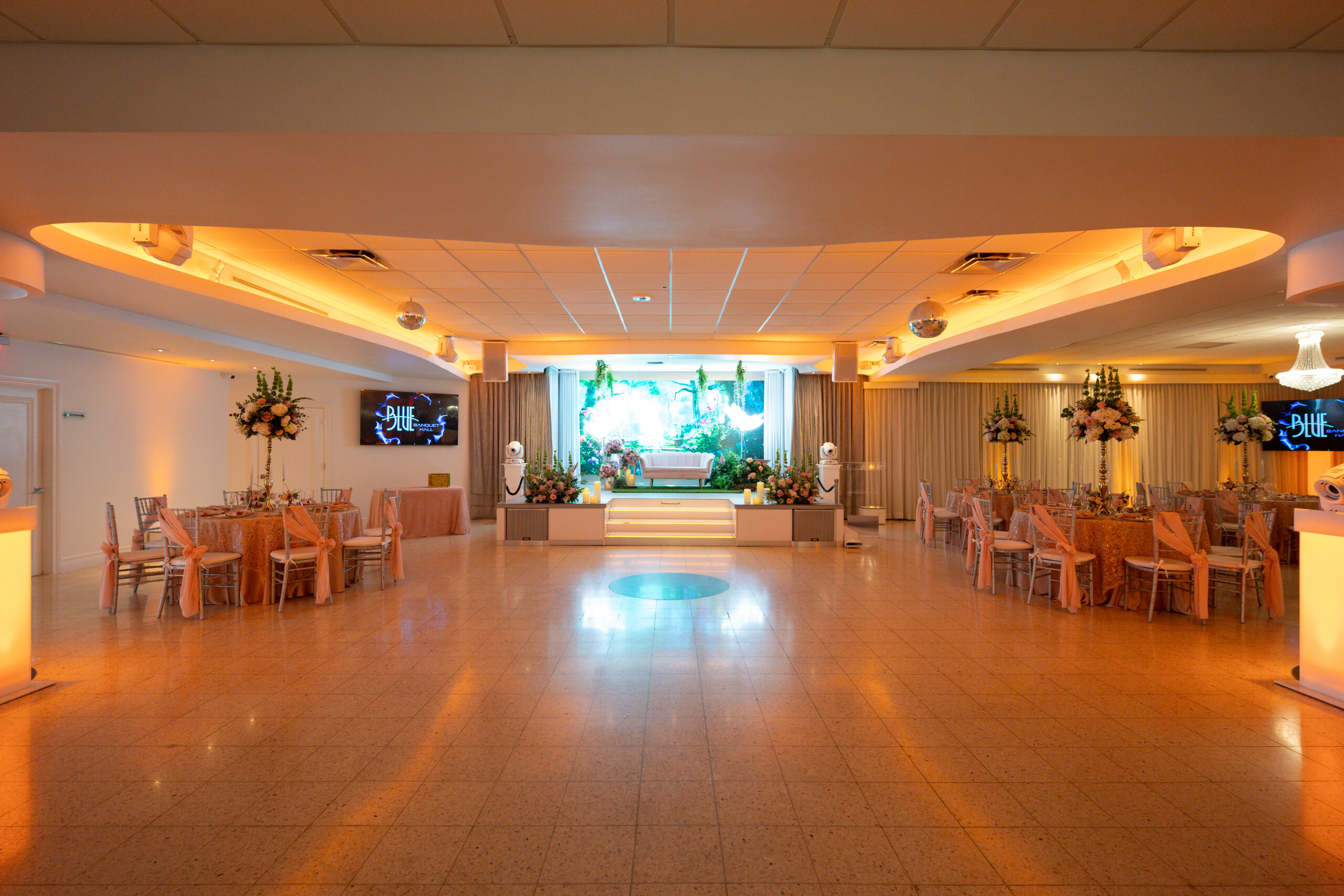 The hall empty, showing the stage, dance floor and chandeliers